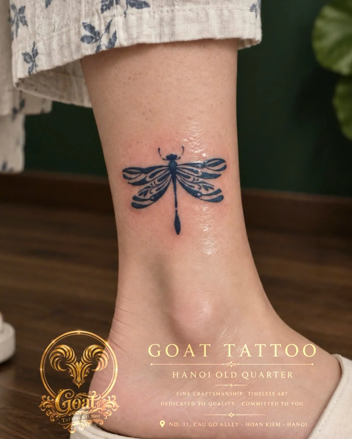 A blue ornamental dragonfly tattoo on the ankle, by GOAT Tattoo Studio Hanoi.