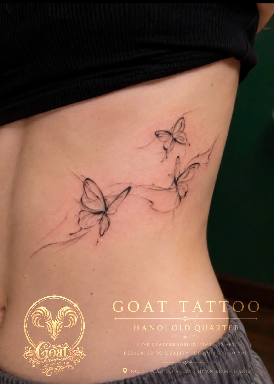 A trio of fine line sketch-style butterflies tattooed down the ribs, by GOAT Tattoo Studio in Hanoi's Old Quarter.