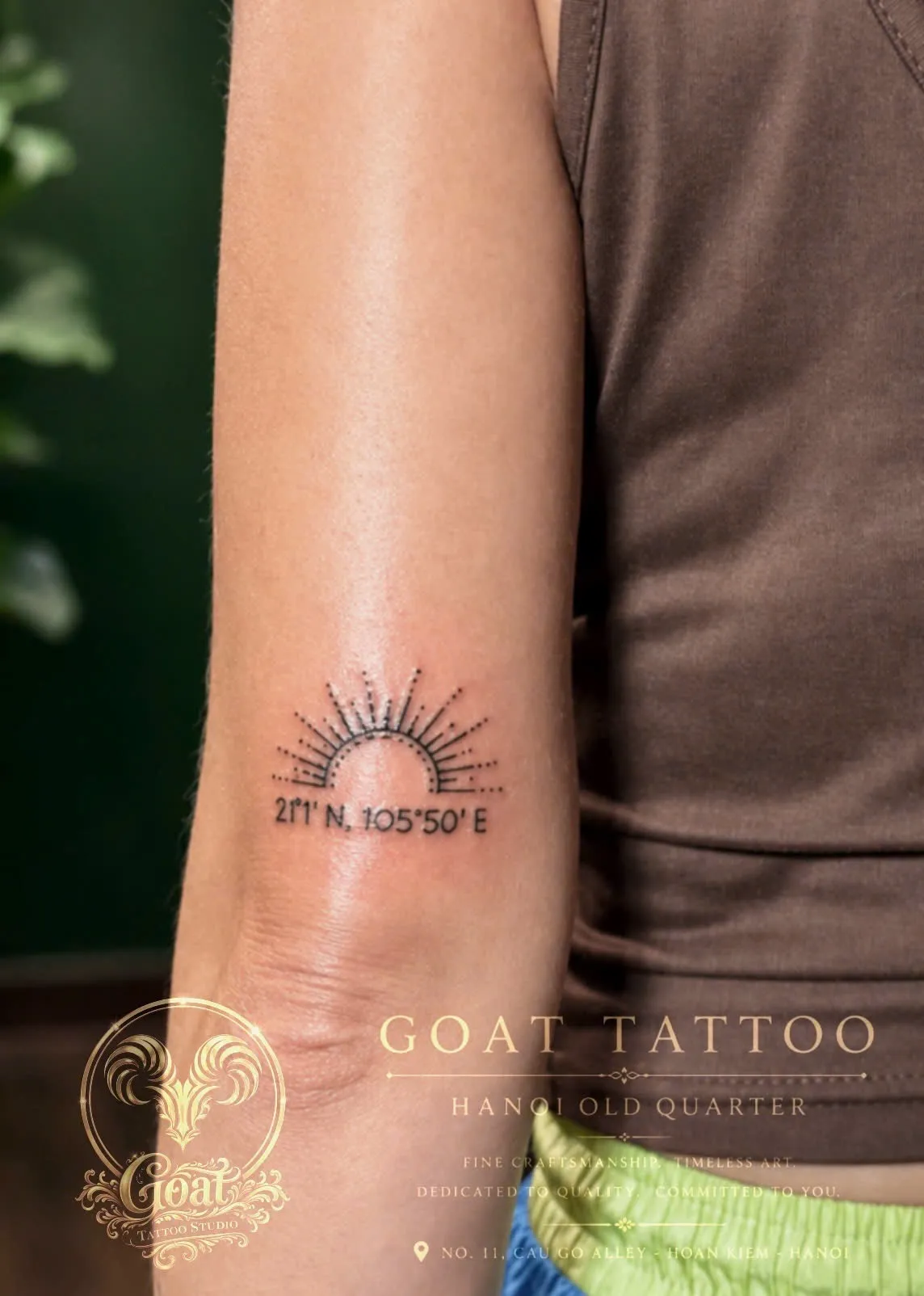 A dotwork sunrise tattoo with Hanoi's coordinates, on the upper arm, by GOAT Tattoo Studio in Hanoi's Old Quarter.
