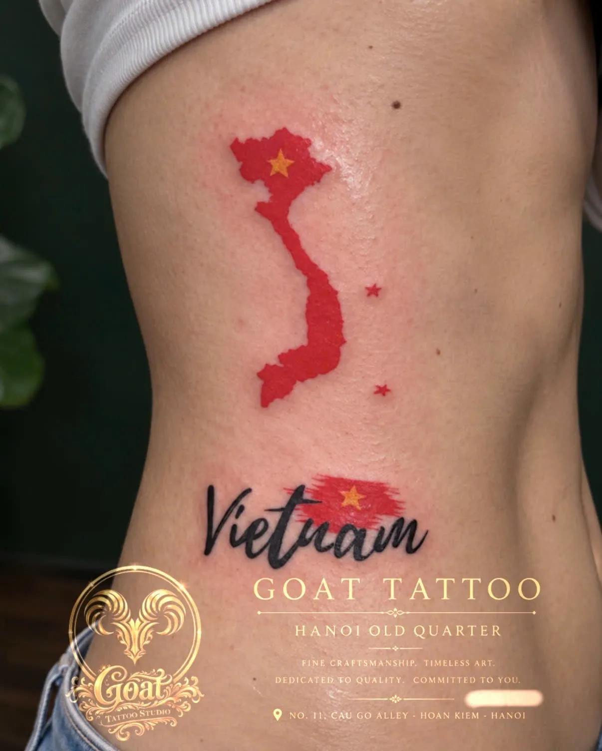 The map of Vietnam in red alongside a brush-stroke Vietnam flag and lettering, tattooed down the ribs, by GOAT Tattoo Studio in Hanoi's Old Quarter.